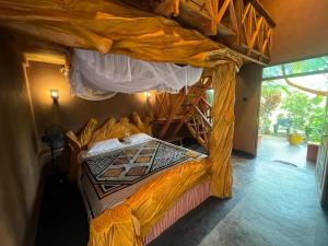 a bedroom with a canopy bed with a wooden ladder at Ama Eco Lodge in Sigiriya