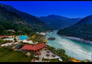 an aerial view of a river with mountains at ALOHA DIVINE GANGES APARTMENTS with INFINITY POOL in Rishīkesh +2 photos