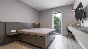 - une chambre avec un lit et un bureau dans l'établissement AV apart hotel, à Senec