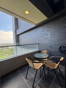 a patio with a table and chairs and a window at Haiyu Island Spring Apartment in Toucheng