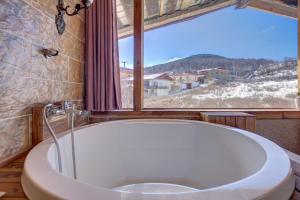 uma banheira na casa de banho com uma janela em Shangri-La Youran Valley Inn em Shangri-La