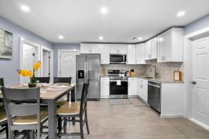 a kitchen with white cabinets and a table with chairs at 3 Bedroom Apartment on Forestville Bristol in Bristol +22 photos