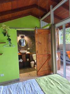 a bedroom with a wooden door and a green wall at Casita Maripier Colón 