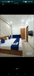 Hotel 7star near airport في إندوري: غرفة نوم بسرير كبير مع وسائد زرقاء