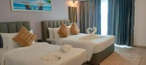 um quarto com duas camas com bichos de peluche em Remas Hotel Hatyai em Hat Yai