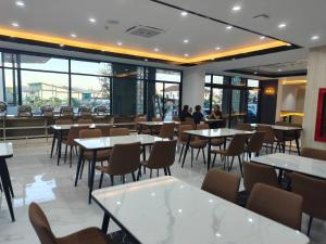a restaurant with tables and chairs and people in the background at Remas Hotel Hatyai in Hat Yai