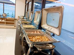 une rangée de plateaux remplis de nourriture sur une table dans l'établissement Remas Hotel Hatyai, à Hat Yai