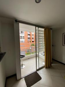 a room with a sliding glass door with a balcony at Emporium Medellín Laureles in Medellín