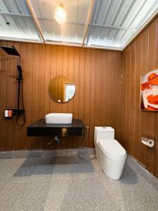 ein Badezimmer mit einem WC, einem Waschbecken und einem Spiegel in der Unterkunft Romhaey Kirirom Resort in Kampong Seila