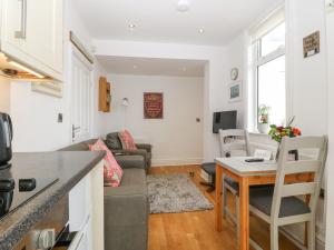 a kitchen and living room with a couch and a table at Gables Retreat in Trearddur