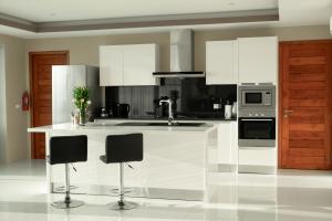 a kitchen with white cabinets and a white counter top at Harmony Sea View Villa in Chaweng Noi Beach