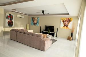a living room with a couch and a tv at Harmony Sea View Villa in Chaweng Noi Beach