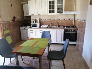 Il comprend une cuisine équipée d'une table, de chaises et d'une cuisinière. dans l'établissement Barok Appart, à Braşov