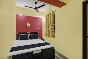 a bedroom with a bed with a red wall at OYO 27 DEGREE HOTEL in Jamshedpur