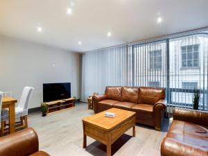 sala de estar con muebles de cuero y TV de pantalla plana en Central - Sleeps 10 - 6 beds, 2 bath, Parking, Gym, en Liverpool