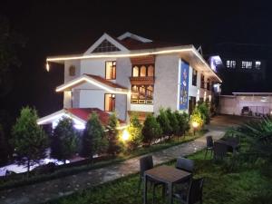a white house with a table in front of it at night at Kunden Village Resort in Gangtok