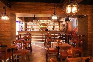 un restaurante con mesas de madera, sillas y luces en Imperial Heights en Deoghar