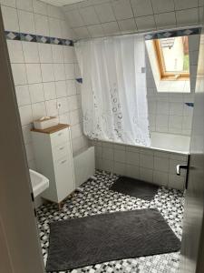 ein Badezimmer mit einer Dusche, einer Badewanne und einem Waschbecken in der Unterkunft Ferienwohnung Alpenblick in Benningen