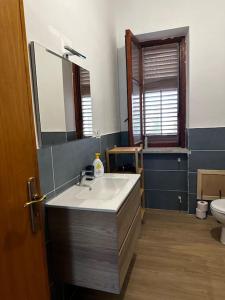 a bathroom with a sink and a mirror and a toilet at Villa Gelsomini in Carini