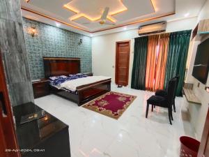 a bedroom with a bed and a table and a chair at 2 bedroom Independent house Valencia town Lahore in Lahore