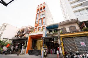 Un edificio in una strada con persone che ci stanno davanti di TRẠNG NGUYÊN HUẾ HOTEL a Hue