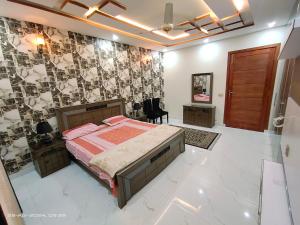 a bedroom with a bed and a wall with photographs at 2 bedrooms Independent house Valencia town Lahore in Lahore