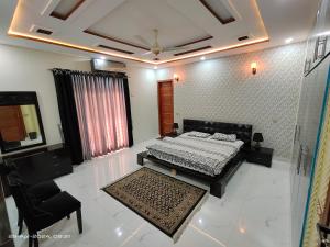 um quarto com uma cama e uma cadeira num quarto em 2 bedrooms Independent house Valencia town Lahore em Lahore