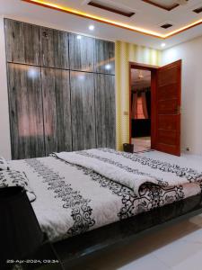 - une chambre avec un grand lit et un mur en bois dans l'établissement 2 bedrooms Independent house Valencia town Lahore, à Lahore