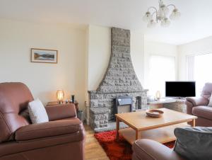 a living room with a couch and a fireplace at Frondeg in Tregarth