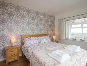 a bedroom with a bed with two towels on it at Frondeg in Tregarth