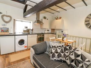 a living room with a couch and a kitchen at In & Out Cottage in Middleham