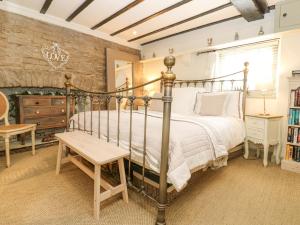 a bedroom with a metal bed and a table at In & Out Cottage in Middleham