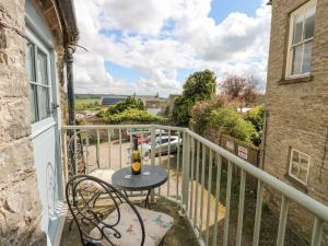 a table with a bottle of wine on a balcony at In & Out Cottage in Middleham