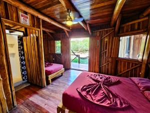 a bedroom with two beds in a room with wooden walls at Don Jon*s in Santa Teresa Beach