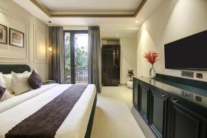 a bedroom with a large bed and a flat screen tv at Saltstayz Amara - Near MG Road and Sector 29 in Gurgaon