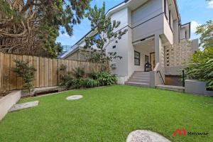 a backyard with a fence and grass at MetaWise Luxury Haven 4 Bed in Central Double Bay in Sydney