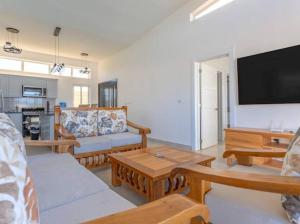 a living room with couches and a flat screen tv at Caribbean Paradise Villa - 3 bed, 3 Bath and Pool in Sosúa
