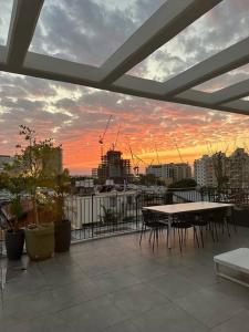 balcón con mesa y vistas a la ciudad en HaKerem new luxury 3 rooms apartments and 2 rooms penthaus, en Tel Aviv