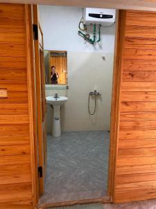 a bathroom with a sink and a person in a mirror at Dung & Sang House in Sapa
