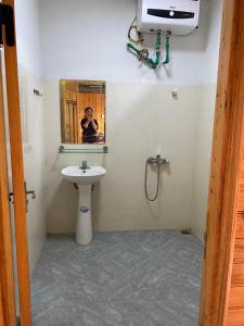 a person taking a picture of a bathroom with a sink at Dung & Sang House in Sapa