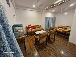 a room with a table and a couch and a bed at Tirupati home stay in Ujjain