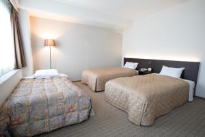 Postel nebo postele na pokoji v ubytování Hotel Aisul Matsuyama