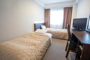Postel nebo postele na pokoji v ubytování Hotel Aisul Matsuyama