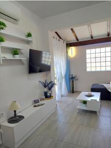 a white living room with a couch and a table at Thanos Guesthouse Corfu in Áyioi Dhéka