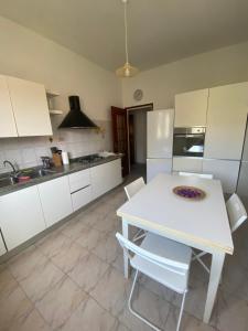uma cozinha com uma mesa branca e armários brancos em Casa di Bianca em Lerici
