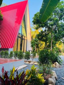 un edificio con tetto rosso e giardino di HOLY VILLA A Frame 3beds 1sofa bed 1bathroom a Kampot