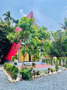 una casa con techo rojo y un árbol en HOLY VILLA A Frame 3beds 1sofa bed 1bathroom, en Kampot