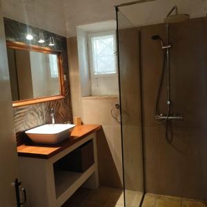 ein Bad mit einem Waschbecken und einer Dusche in der Unterkunft Pietra Bianca in Koríthion