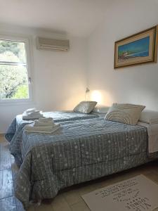 a bedroom with two beds and a window at Villetta Ludovica in Solanas