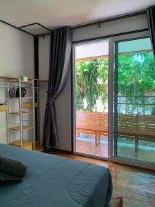 a bedroom with a large sliding glass door to a patio at Mook tawan Beach house in Koh Mook